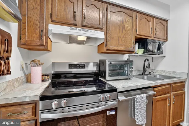 a kitchen with stainless steel appliances granite countertop a stove and a sink
