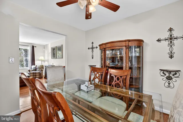 a living room with furniture a dining table and chairs with wooden floor