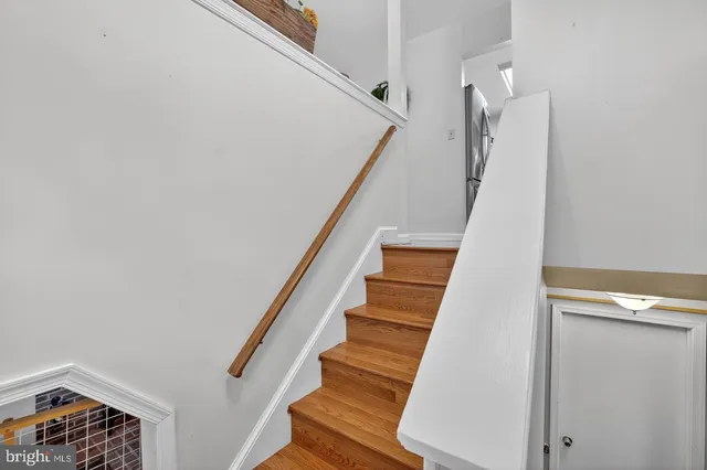a view of staircase with wooden floor and white walls