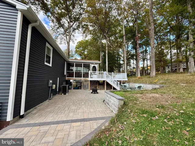 a view of a house with backyard and trees