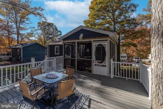 a view of a deck with table and chairs with wooden floor and fence