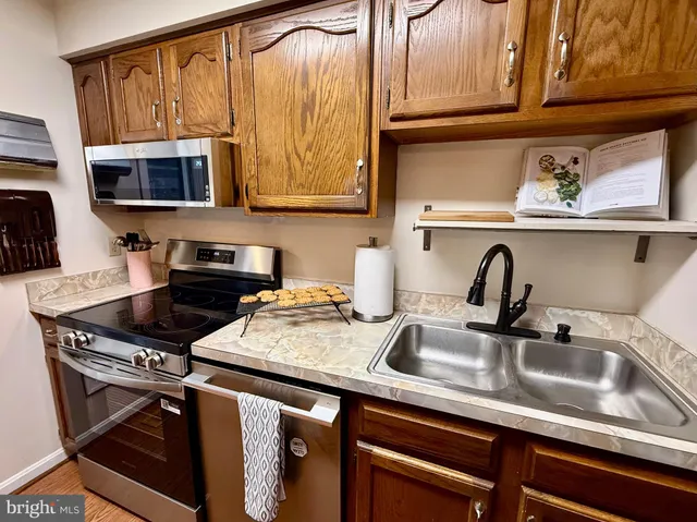 a kitchen with stainless steel appliances granite countertop a sink stove and cabinets