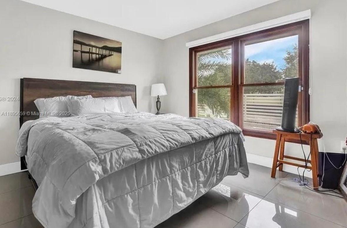 19905 Southwest 135th Avenue Miami, FL 33177 - Photo 14 of 34 a bedroom with a bed and large windows