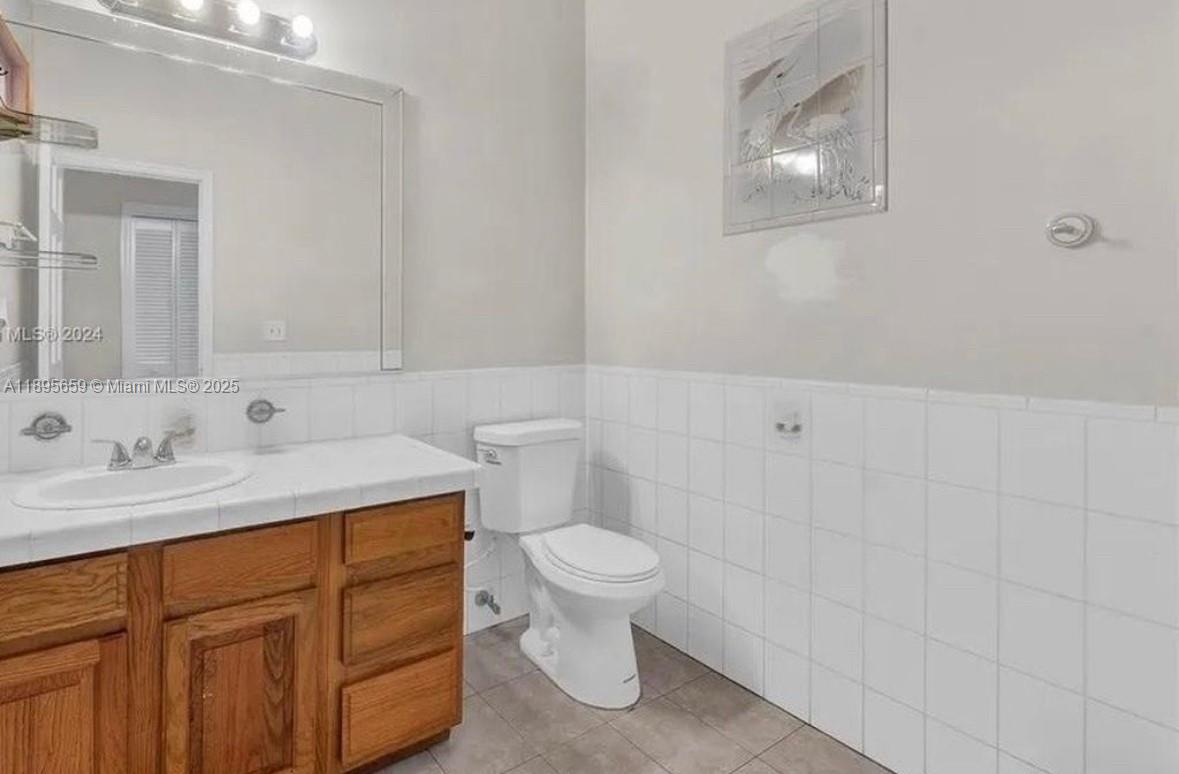 19905 Southwest 135th Avenue Miami, FL 33177 - Photo 16 of 34 a bathroom with a granite countertop toilet sink and mirror