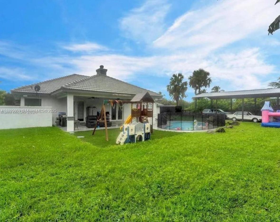19905 Southwest 135th Avenue Miami, FL 33177 - Photo 34 of 34 a front view of a house with a garden and outdoor seating