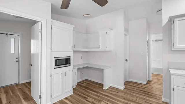 a view of a hallway with wooden floor and staircase