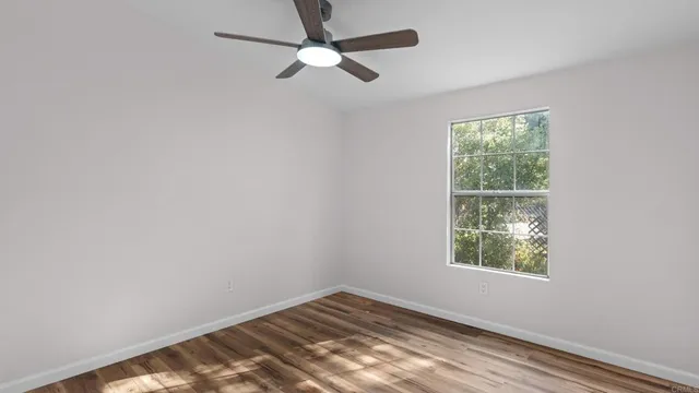 an empty room with a window and a fan