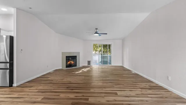a view of an empty room with a window and fireplace