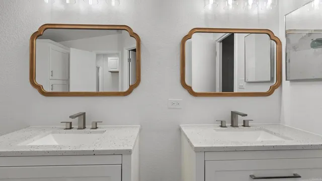 a bathroom with double vanity sinks and a mirror