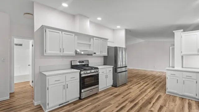 a kitchen with white cabinets and stainless steel appliances