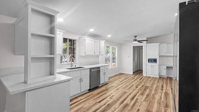 a large kitchen with a sink stainless steel appliances and cabinets