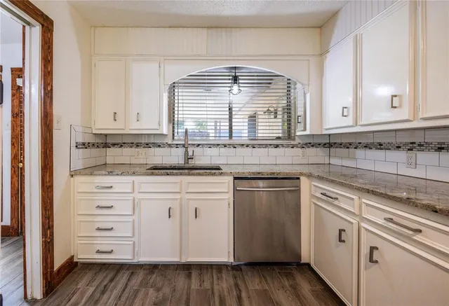 a kitchen with granite countertop white cabinets and white appliances