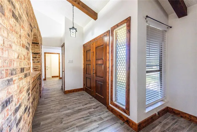 a view of a hallway with wooden floor and staircase