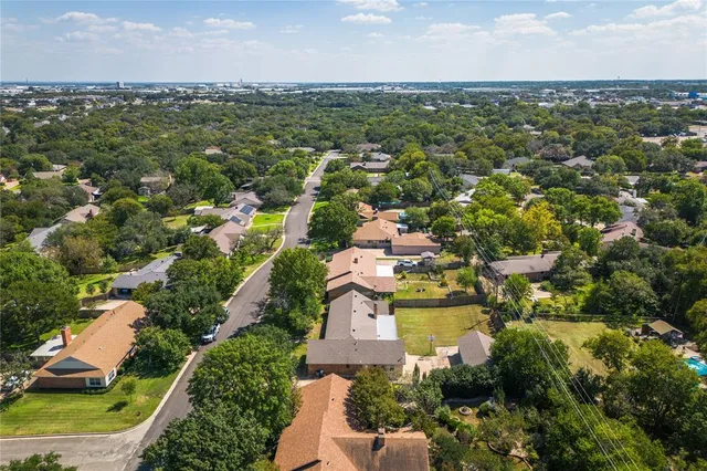 an aerial view of residential houses with outdoor space and trees