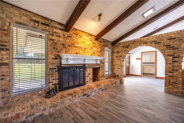 a view of a porch with wooden floor and a fireplace