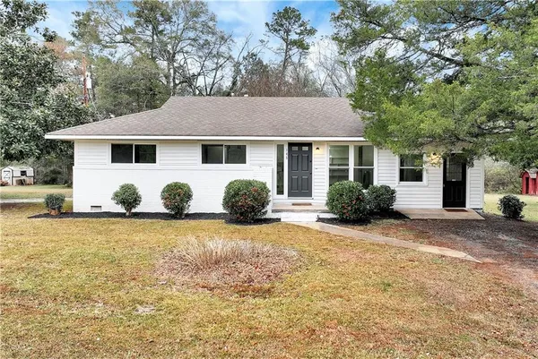 a view of a house with backyard and tree