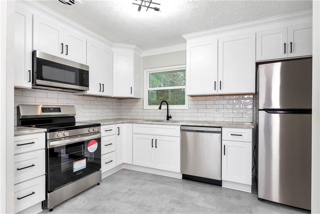 145 Beaverdam Road Winterville, GA 30683 - Photo 14 of 53 a kitchen with white cabinets stainless steel appliances and sink
