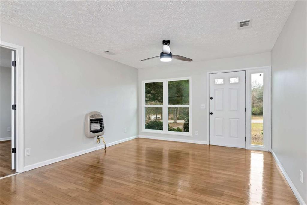 145 Beaverdam Road Winterville, GA 30683 - Photo 14 of 39 a view of an empty room with a window and wooden floor
