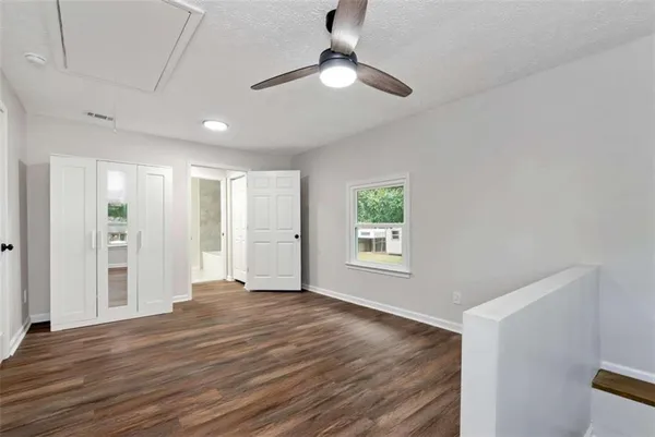 a view of an empty room with window and wooden floor