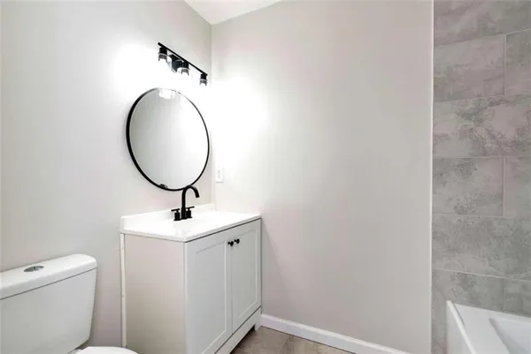 a bathroom with a toilet a sink and a mirror