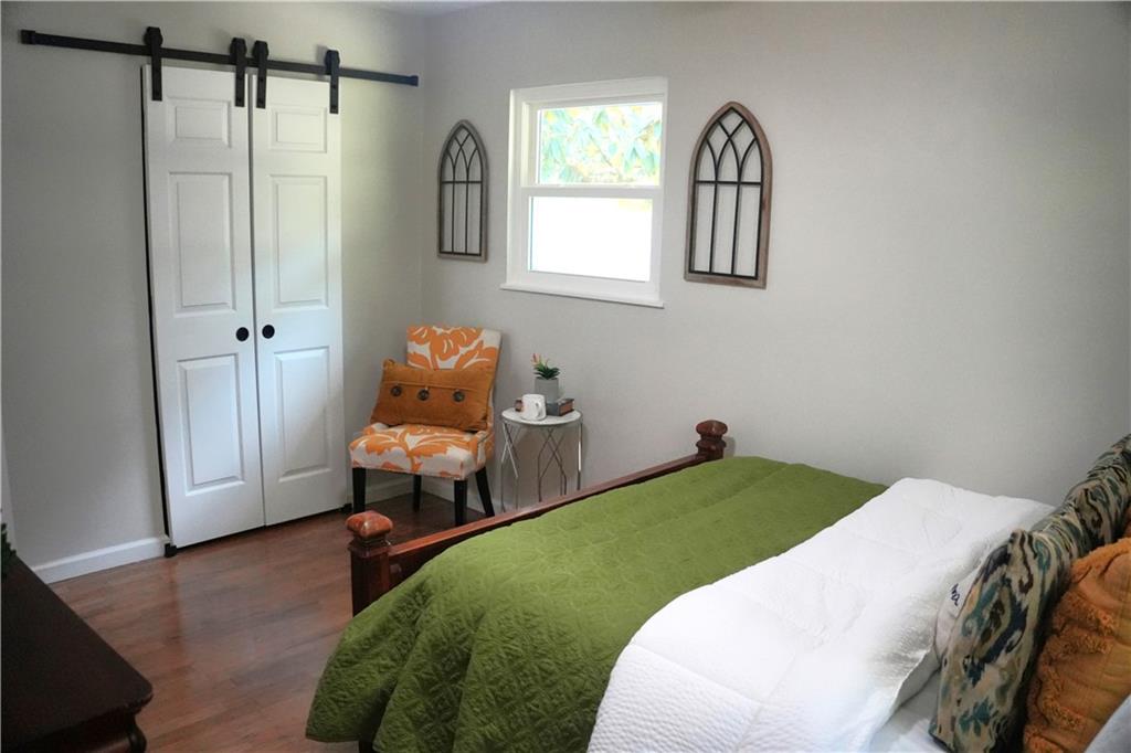 145 Beaverdam Road Winterville, GA 30683 - Photo 31 of 53 a bedroom with a bed and wooden floor