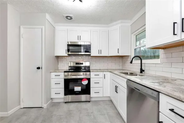 a kitchen with stainless steel appliances granite countertop a sink and a stove