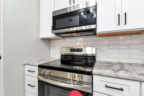 a stove top oven sitting inside of a kitchen