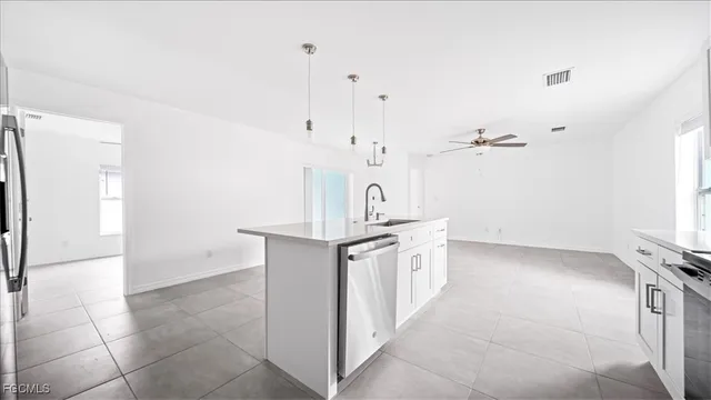 a kitchen with stainless steel appliances granite countertop a sink and a refrigerator