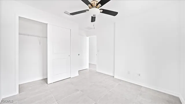 an empty room with a ceiling fan and a fan