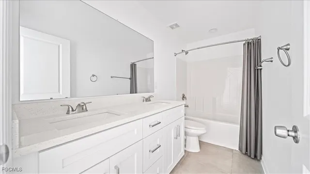 a bathroom with a double vanity sink toilet mirror and shower