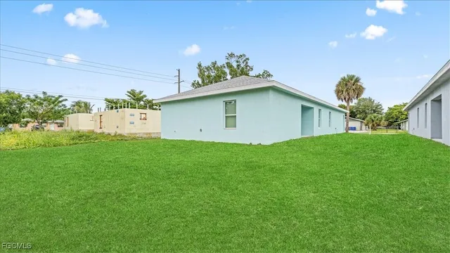 a view of a backyard with plants and large tree