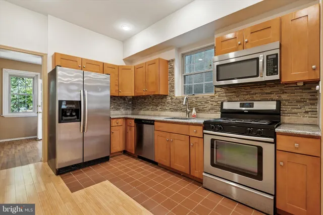 a kitchen with stainless steel appliances granite countertop a stove microwave and refrigerator