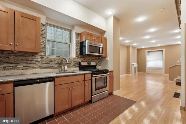 a kitchen with stainless steel appliances granite countertop a stove a sink and a microwave