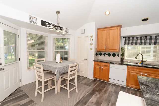 a kitchen with granite countertop stainless steel appliances stove sink table and chairs