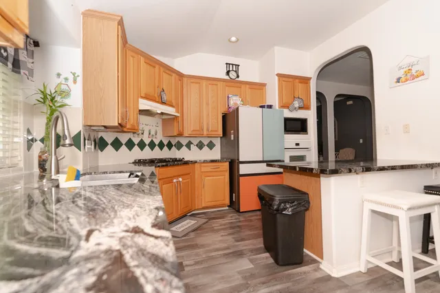 a kitchen with stainless steel appliances granite countertop a refrigerator and stove
