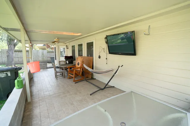 a living room with patio furniture and a flat screen tv