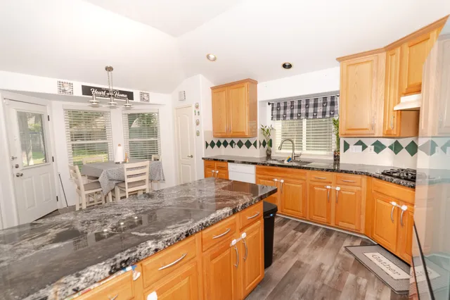 a large kitchen with granite countertop a sink and a stove