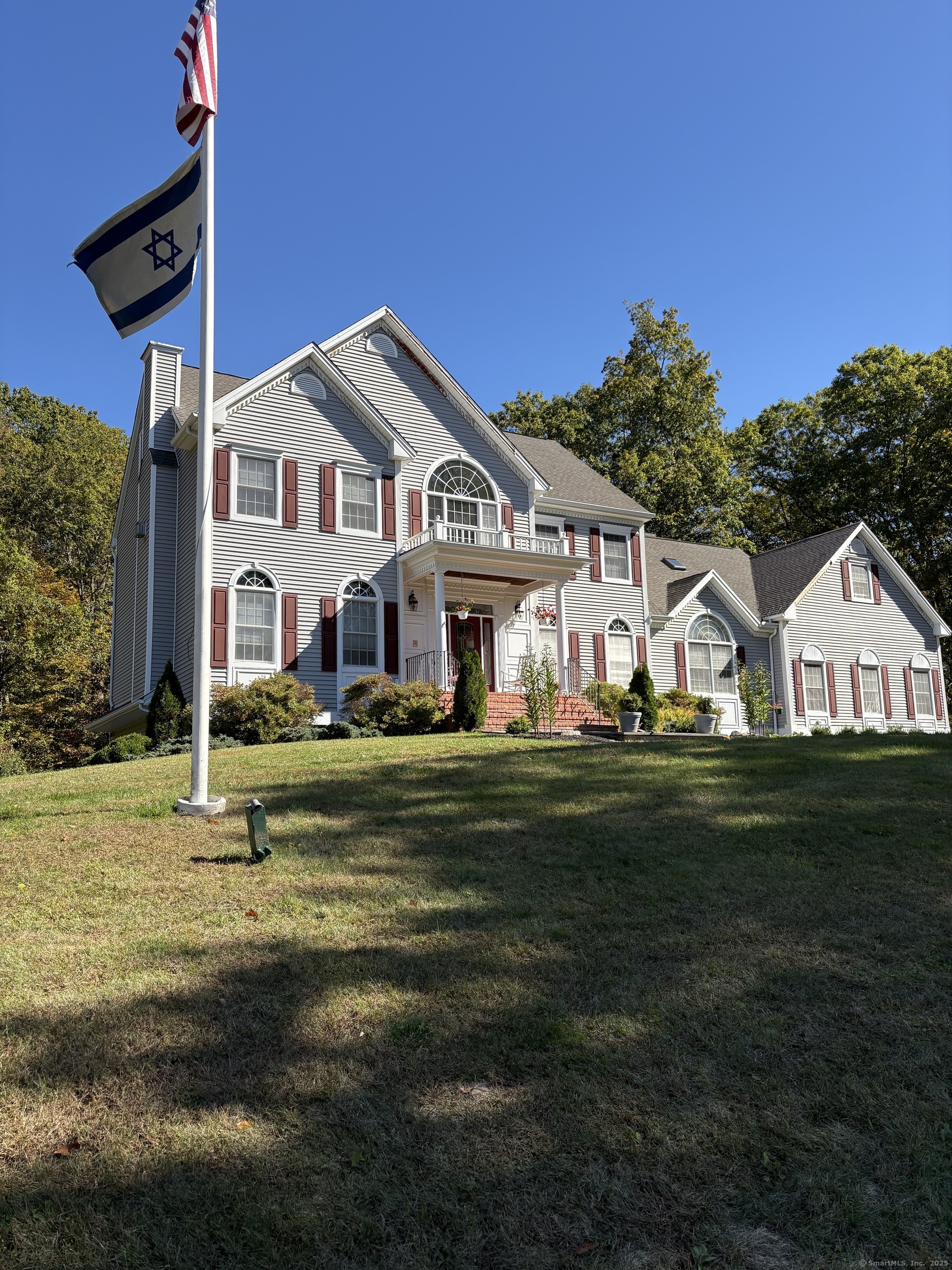a front view of a house with a garden and trees