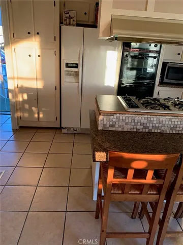 a kitchen with stainless steel appliances granite countertop a stove a refrigerator and a microwave