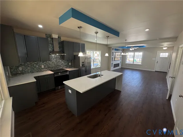 en empty room with windows and chandelier fan