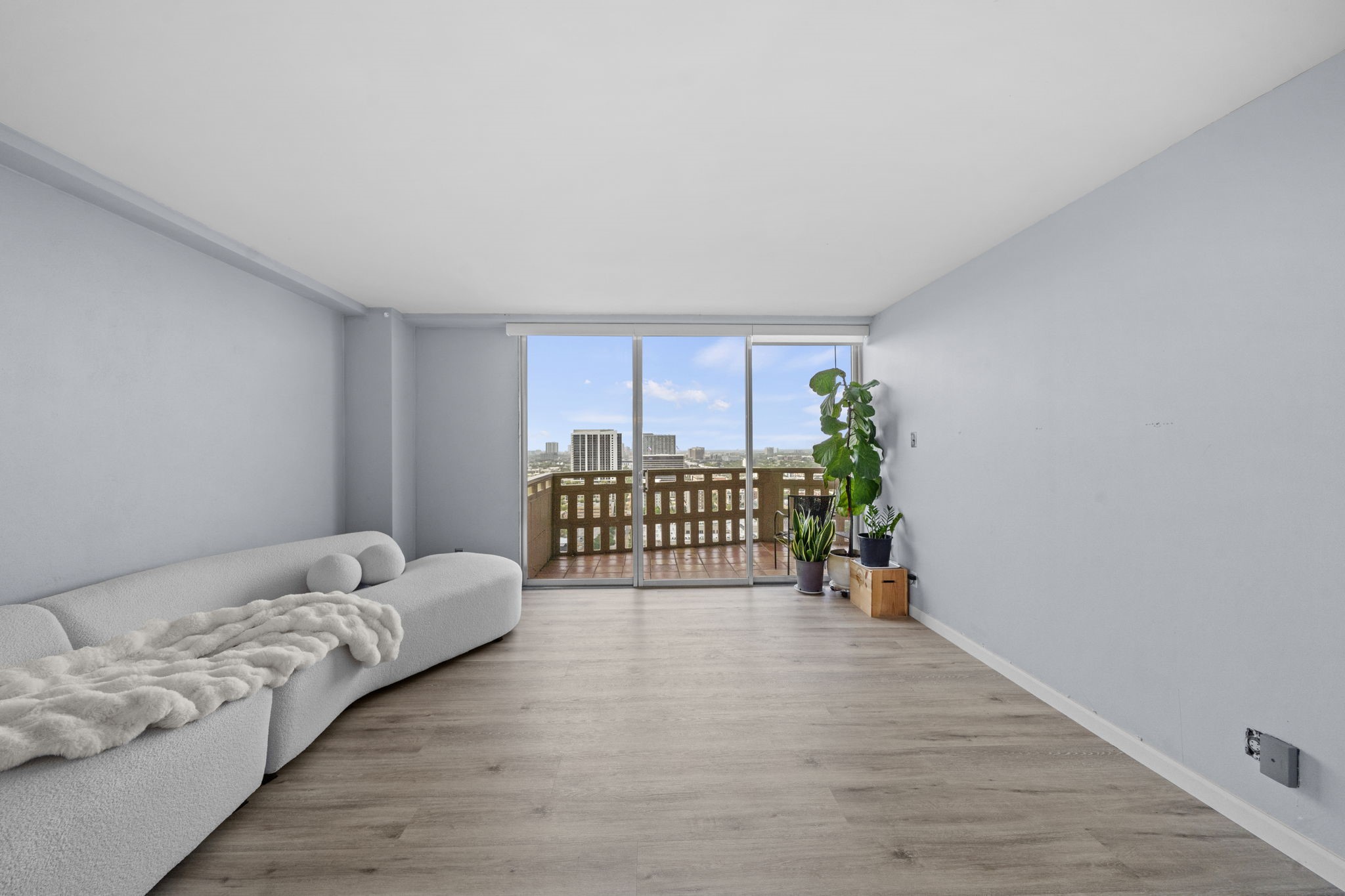2016 Main Street, Unit 2302 Houston, TX 77002 - Photo 4 of 34 Spacious living room filled with natural light and beautiful city views, offering a comfortable space to relax or entertain.