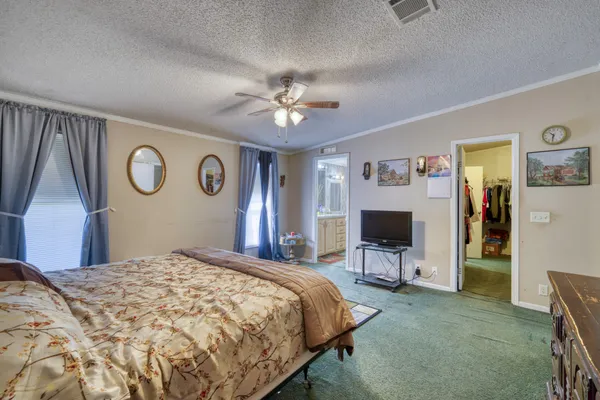 a bedroom with a large bed and a chandelier