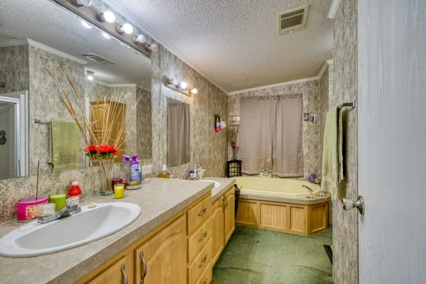 a bathroom with a sink double vanity granite tub shower and a mirror