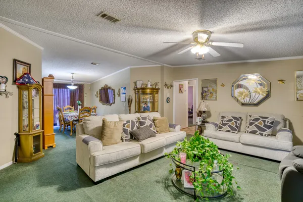 a living room with patio furniture and a chandelier