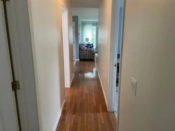 a view of a hallway with wooden floor and staircase