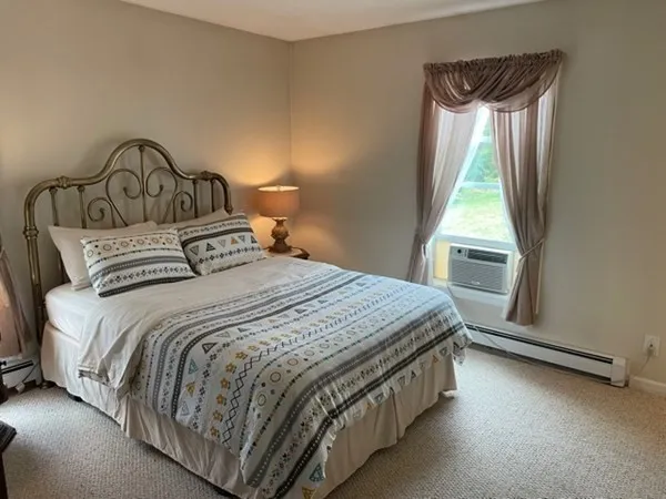 a bedroom with a bed next to a window