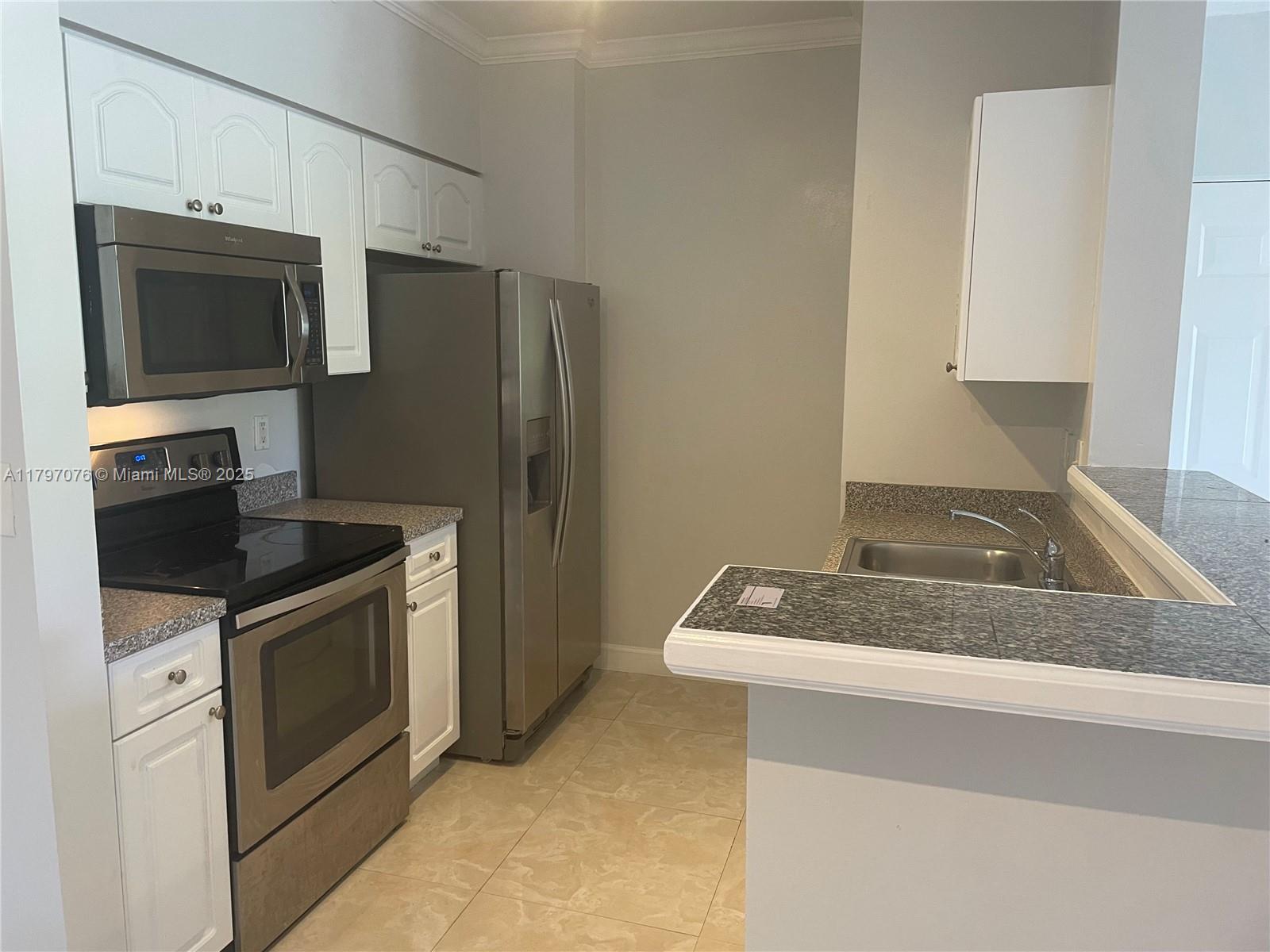 Glenvar Heights Miami, FL 33155 - Photo 3 of 10 a kitchen with stainless steel appliances granite countertop a sink and a microwave