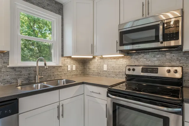 a kitchen with a stove microwave and sink