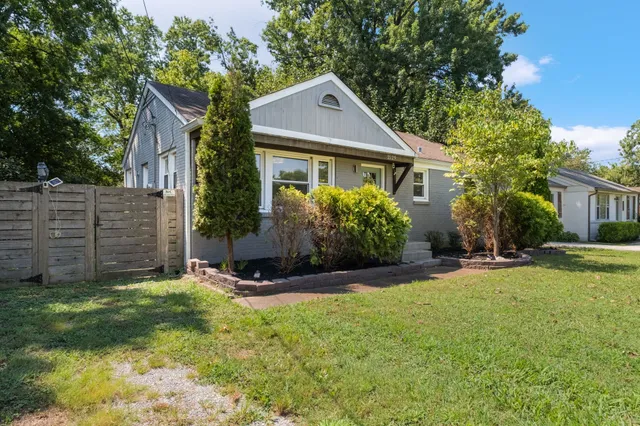 a front view of house with yard and trees