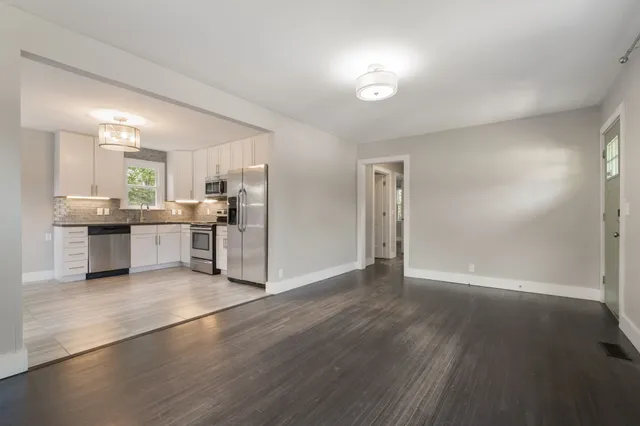 a view of a kitchen with a sink stove cabinets and empty room